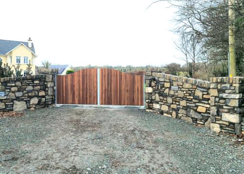 stone wall entrance with teak wood gate